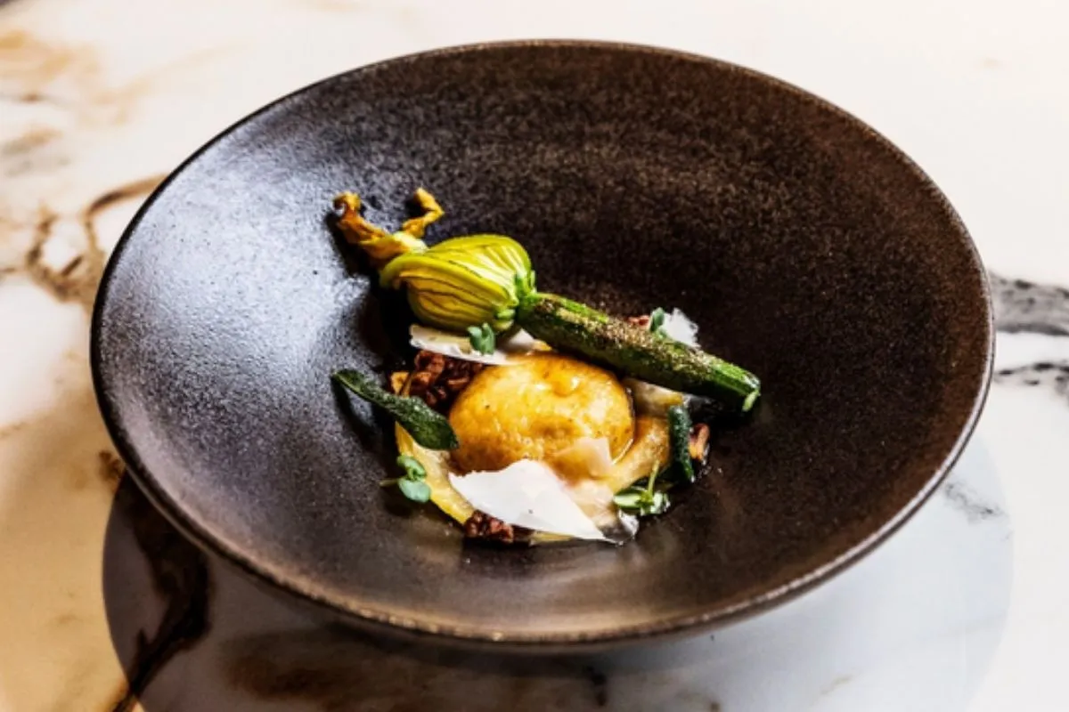 Gourmet stuffed zucchini flower dish served in a dark ceramic bowl at OTO Restaurant, Reykjavik.