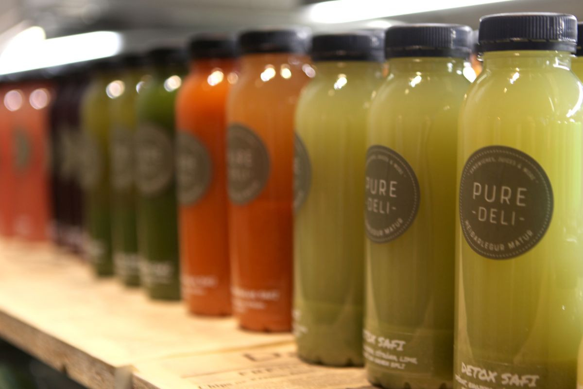 Freshly made green and orange detox juices on display at Pure Deli in Kópavogur