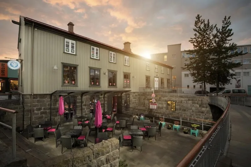 Outdoor seating and historic storefront of Fish Company (Fiskfélagið) in downtown Reykjavik during golden hour.