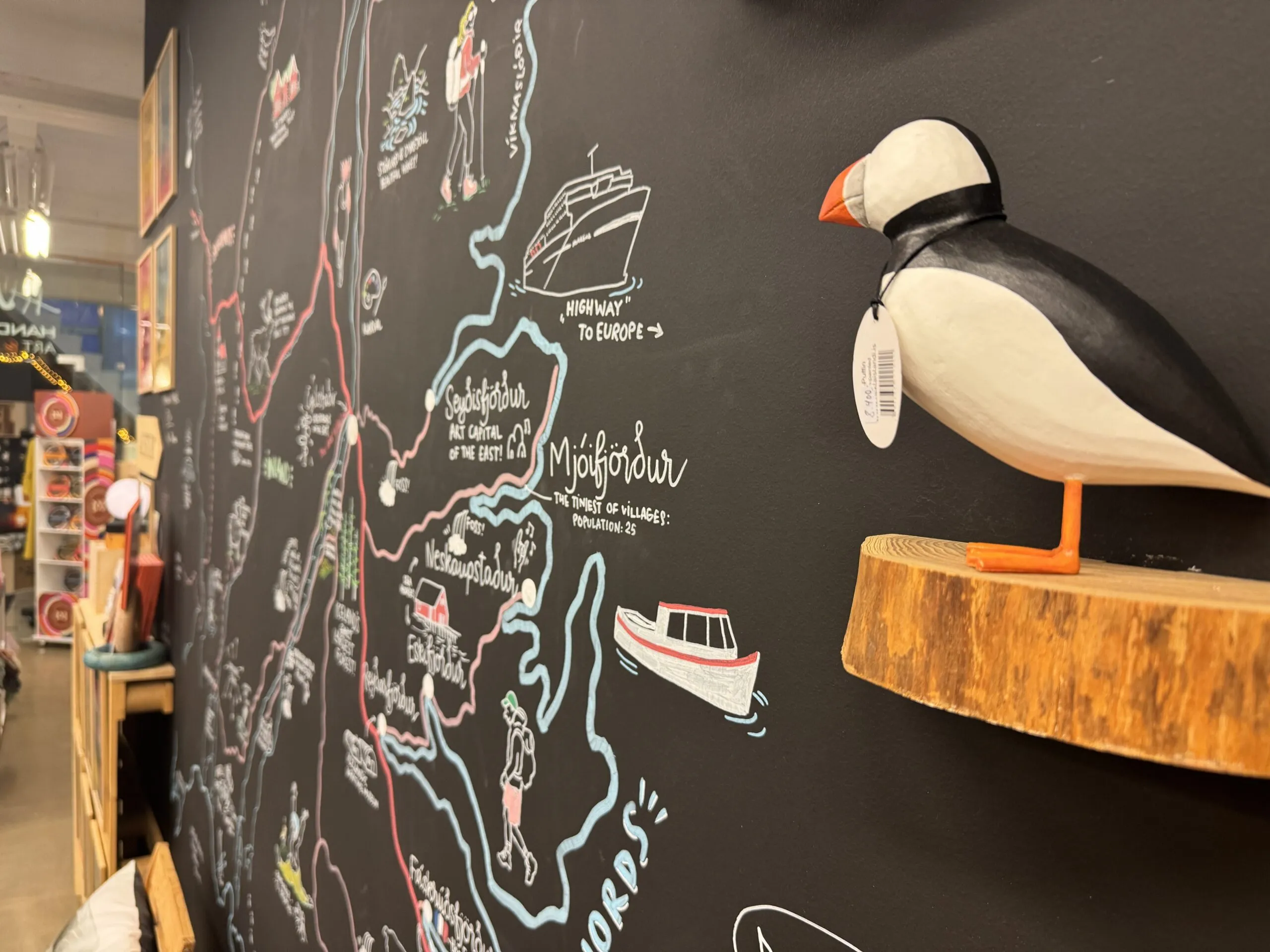 Chalkboard travel map of Eastfjords and wooden puffin at Hús Handanna Craft and Design in Egilsstaðir.