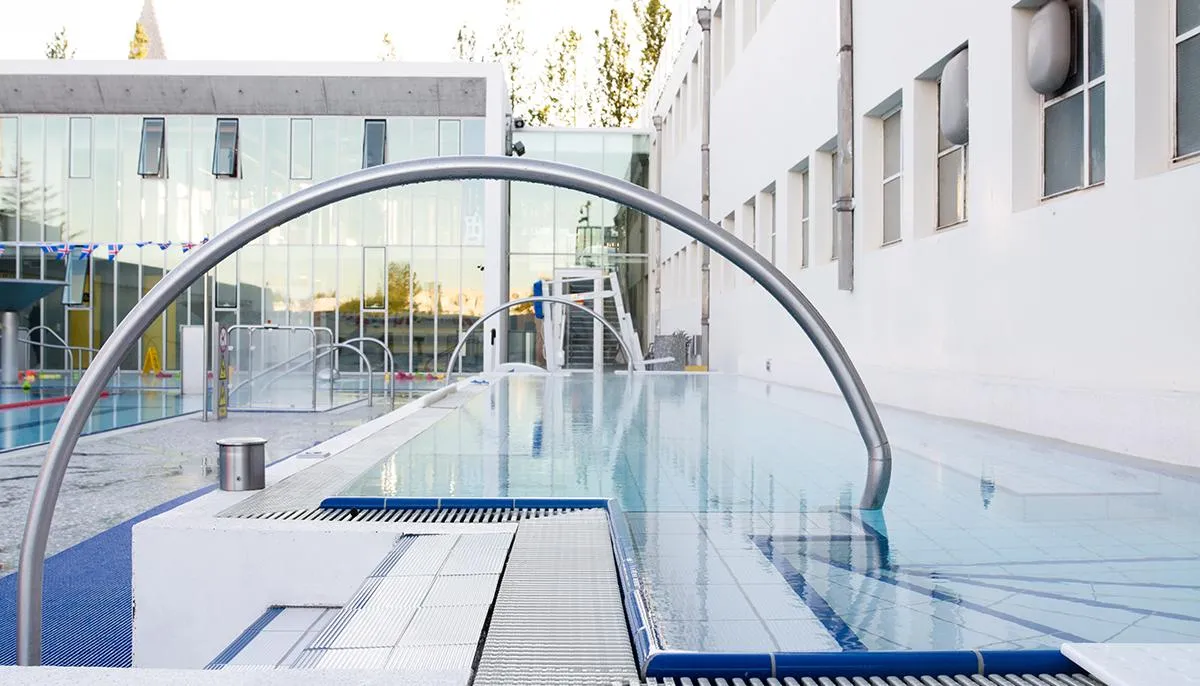 Modern outdoor thermal pool and facilities at Sundhöll Reykjavík.