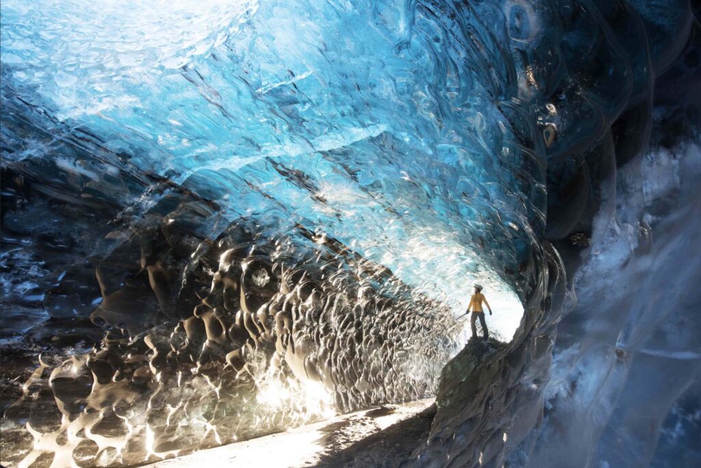 Glacier Journey explorer inside a natural blue ice cave in Iceland.
