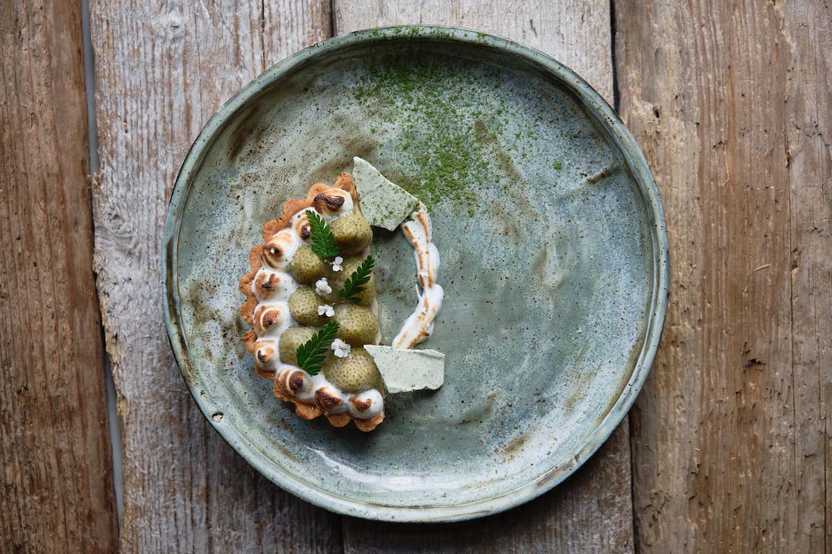 Plated fruit tart on a ceramic dish served at Eyja Wine Bar & Bistro in Akureyri.