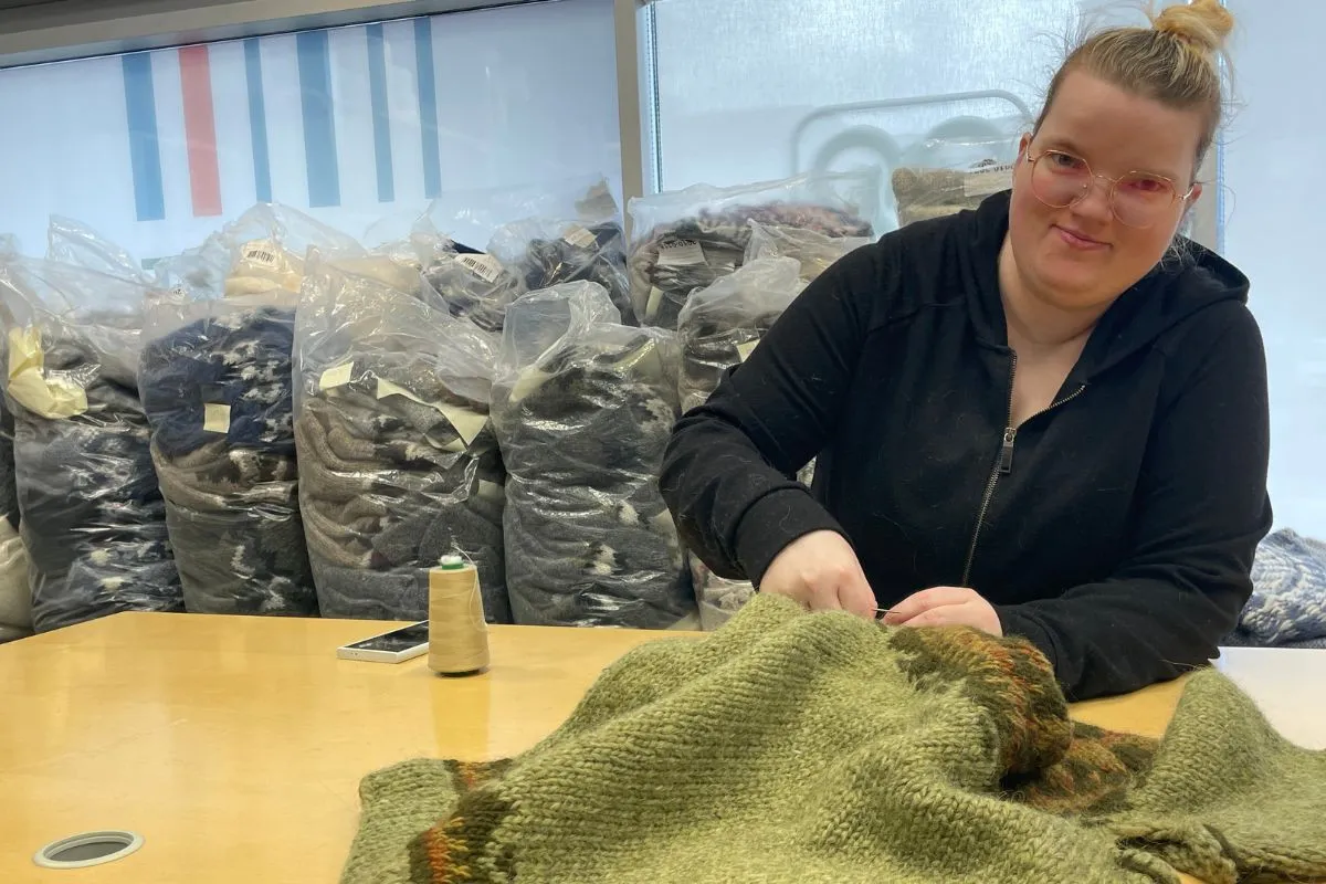 Artisan knitting a green Icelandic wool sweater at Handknitting Association of Iceland in Reykjavik.