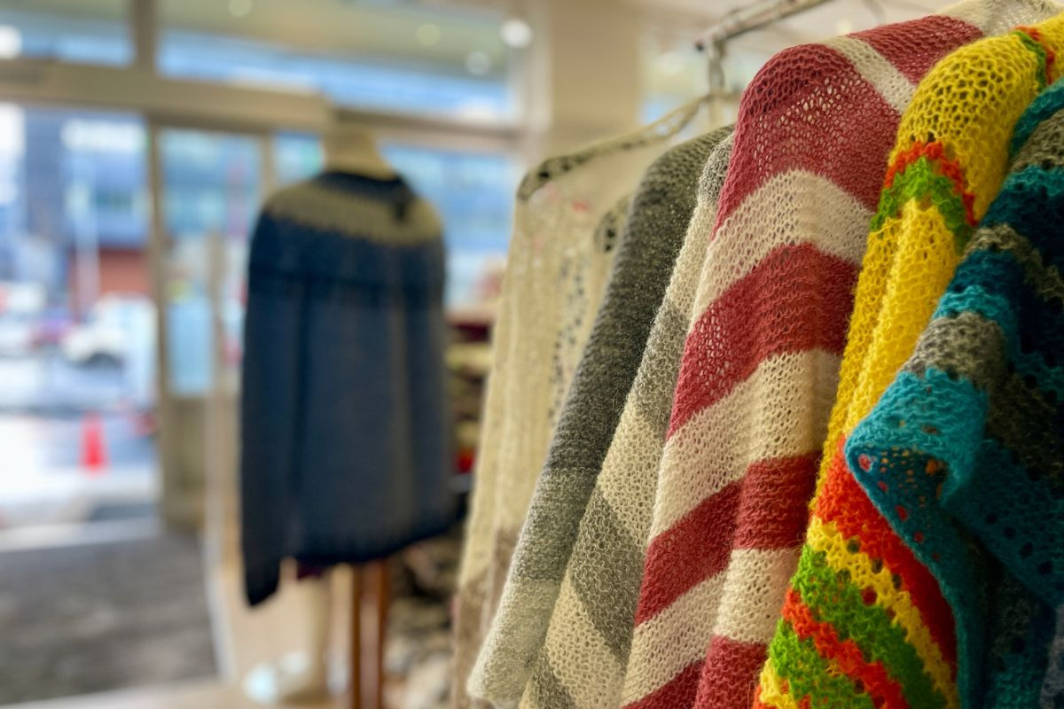 Colorful, lightweight hand-knitted Icelandic wool shawls on a rack at The Handknitting Association of Iceland in Reykjavik.