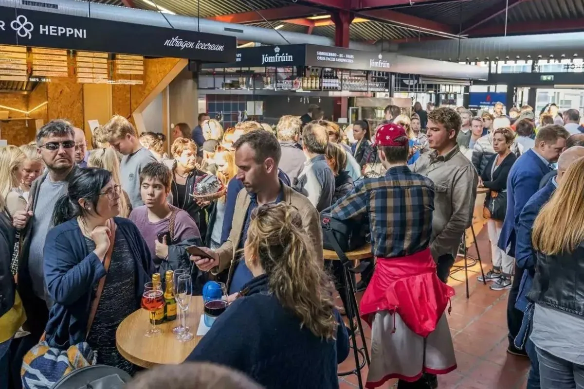 Diverse food stalls and bustling crowd at Hlemmur Foodhall, highlighting communal dining in downtown Reykjavik.