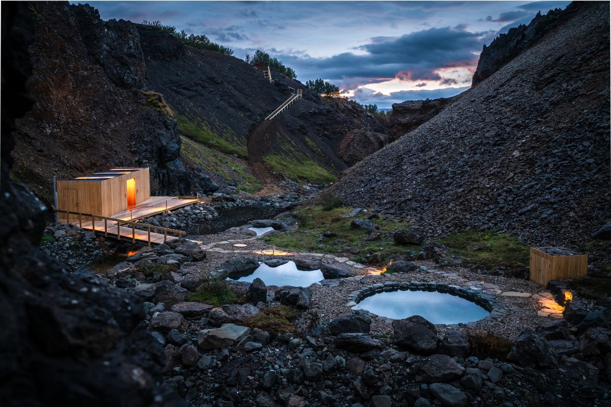 Geothermal pools and a wooden changing bathhouse at Husafell Canyon Baths.