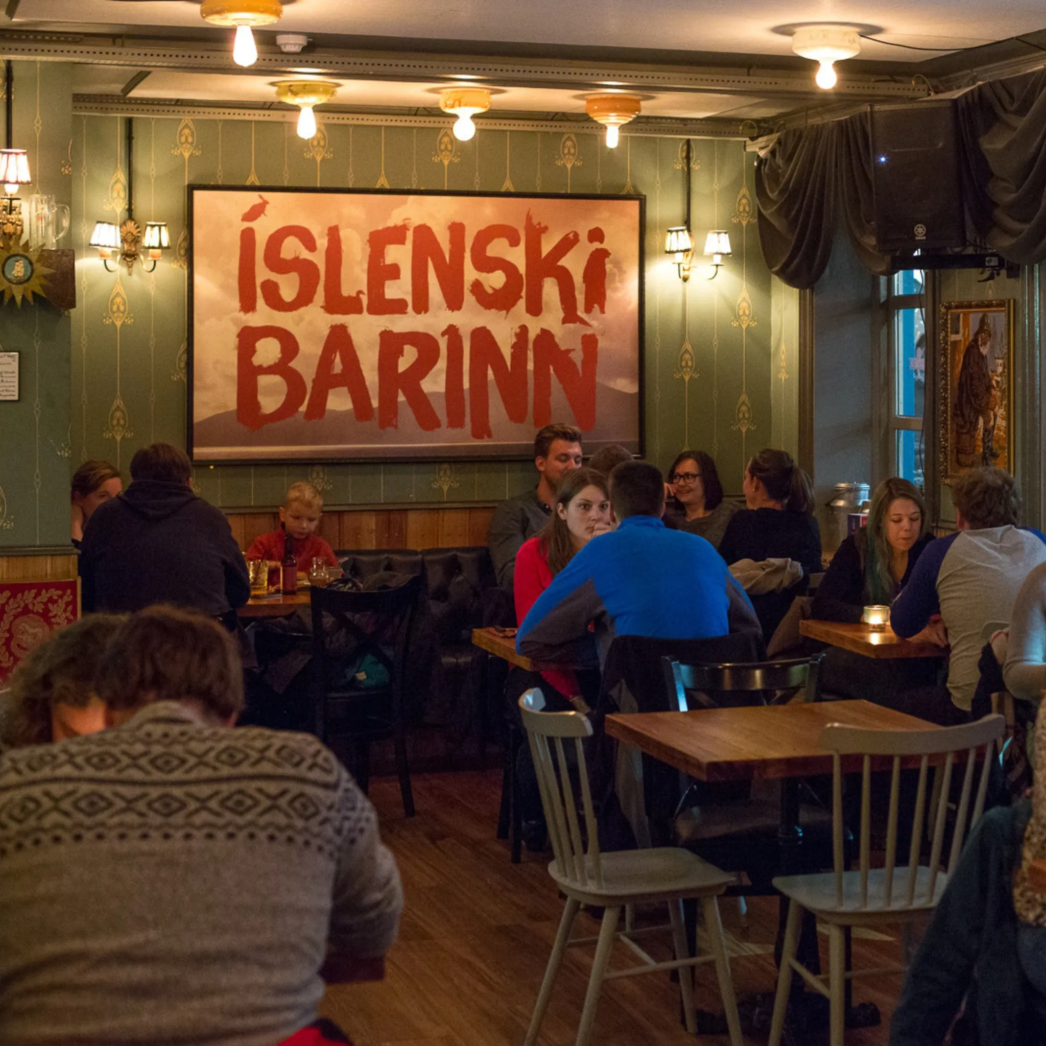 Cozy interior of The Icelandic Bar (Íslenski barinn) with vintage décor and diners in Reykjavik.