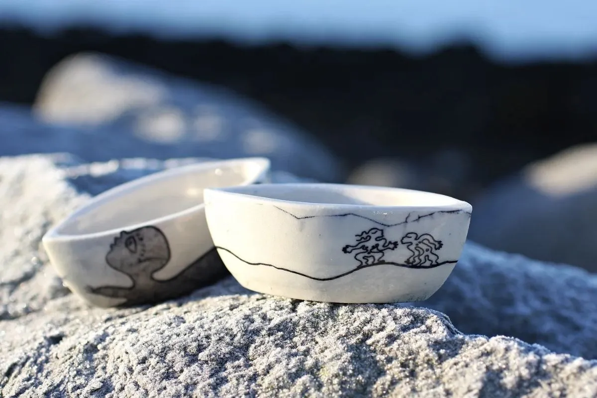 White earthenware figurines with minimalist black line art from Kogga 