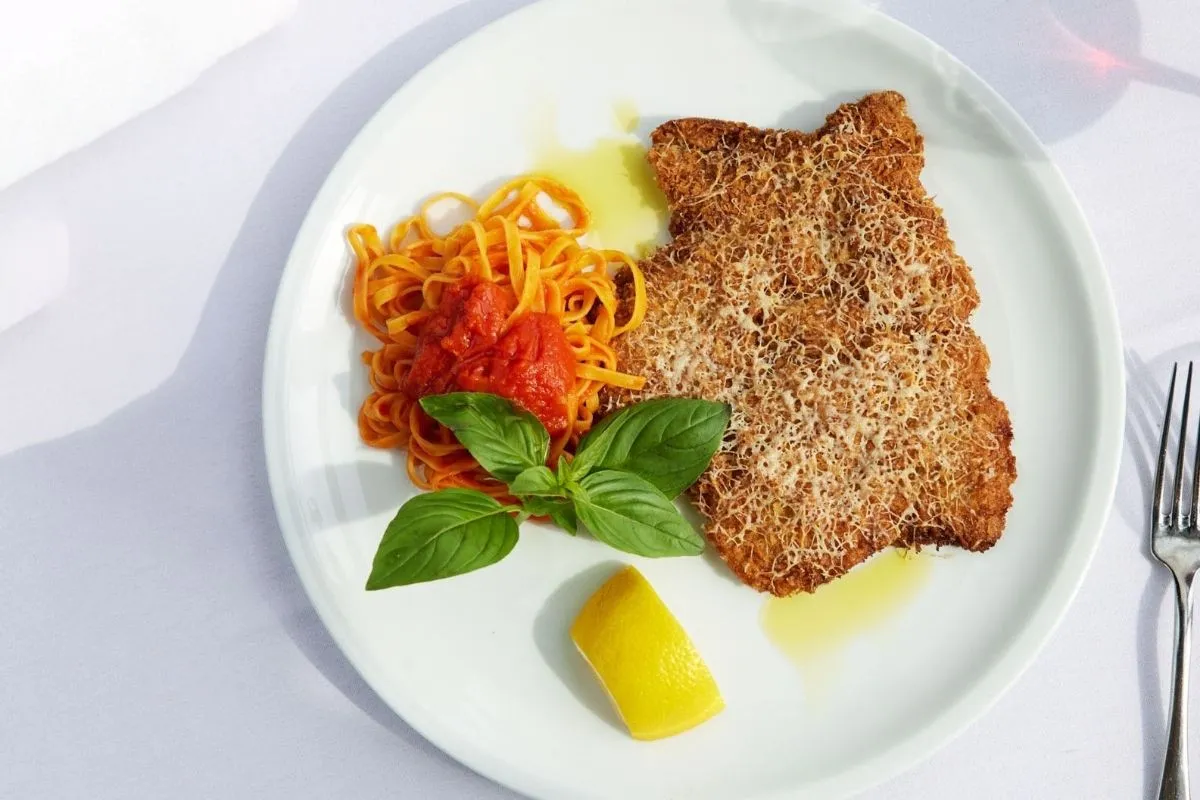 Crispy veal Milanese with tomato linguine and fresh basil at La Primavera Restaurant & Bar in Reykjavik.