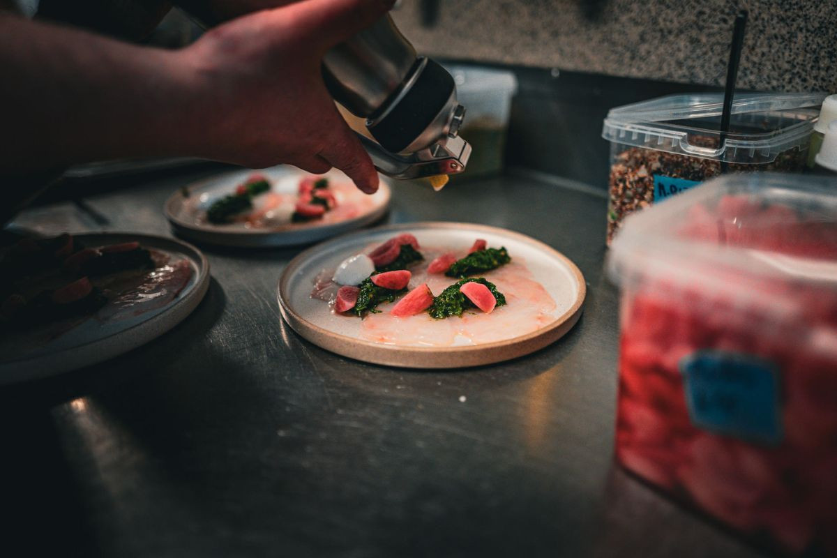 Chef preparing a dish at LYST Café in Akureyri.