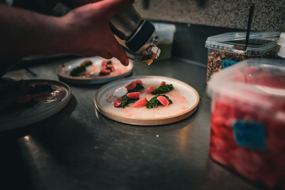 Chef preparing a dish at LYST Café in Akureyri.