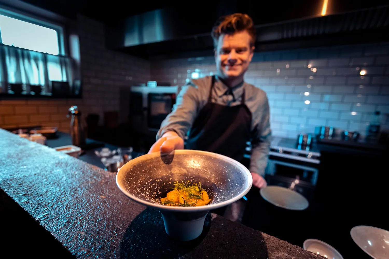 Restaurant chef with a minimalist dish at North Restaurant in Akureyri.