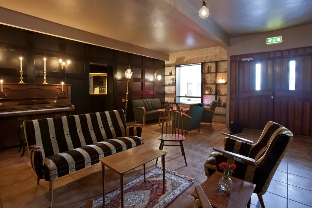 A cozy, retro-themed seating area inside Siglunes Guesthouse in Siglufjörður.