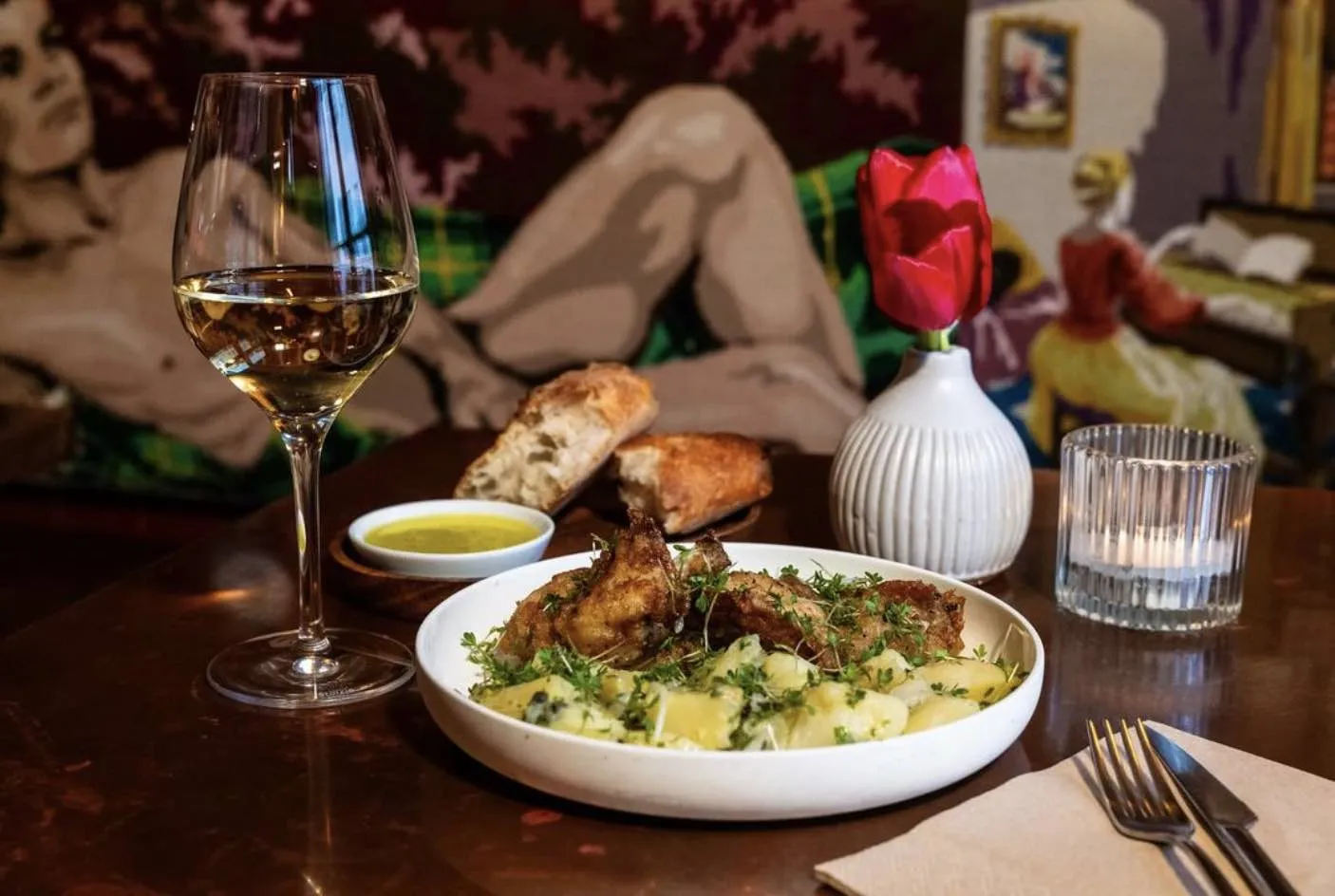 Grilled chicken with potato salad, white wine, and fresh bread at Skreið restaurant and wine bar in Reykjavik.