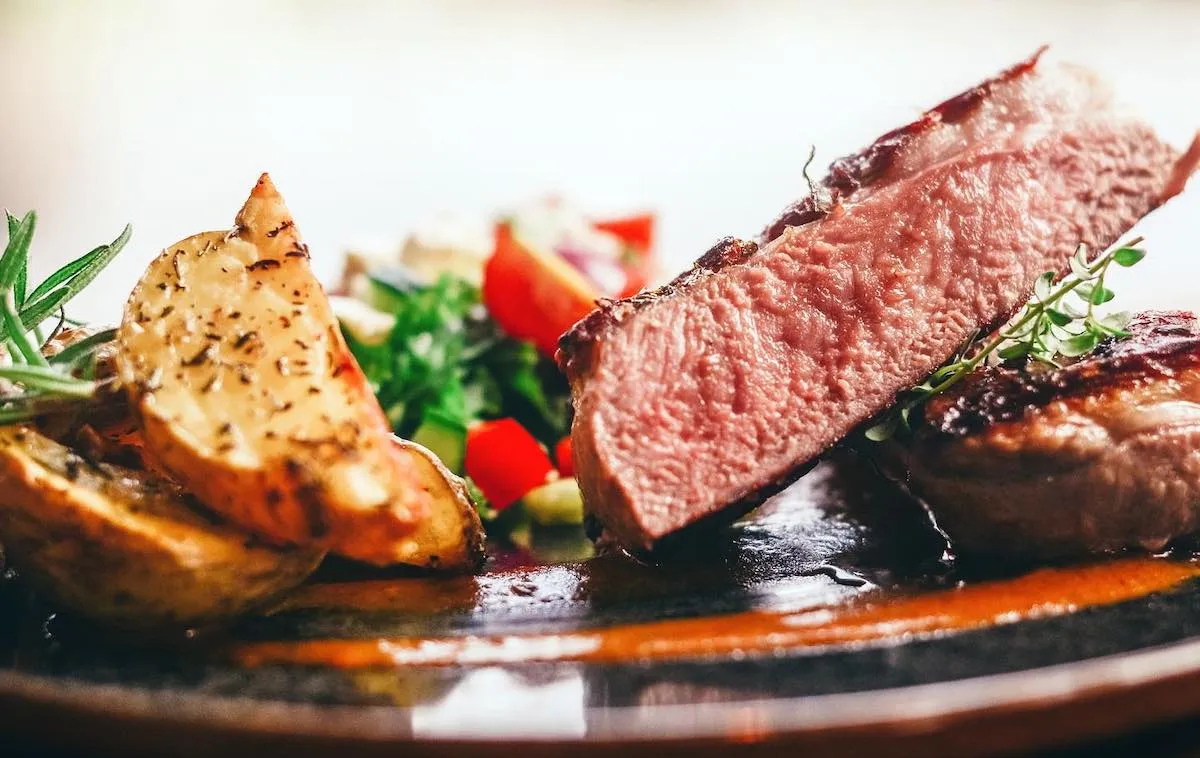 Plated steak with potato wedges and fresh salad at Vogafjós Farm Restaurant in Myvatn.