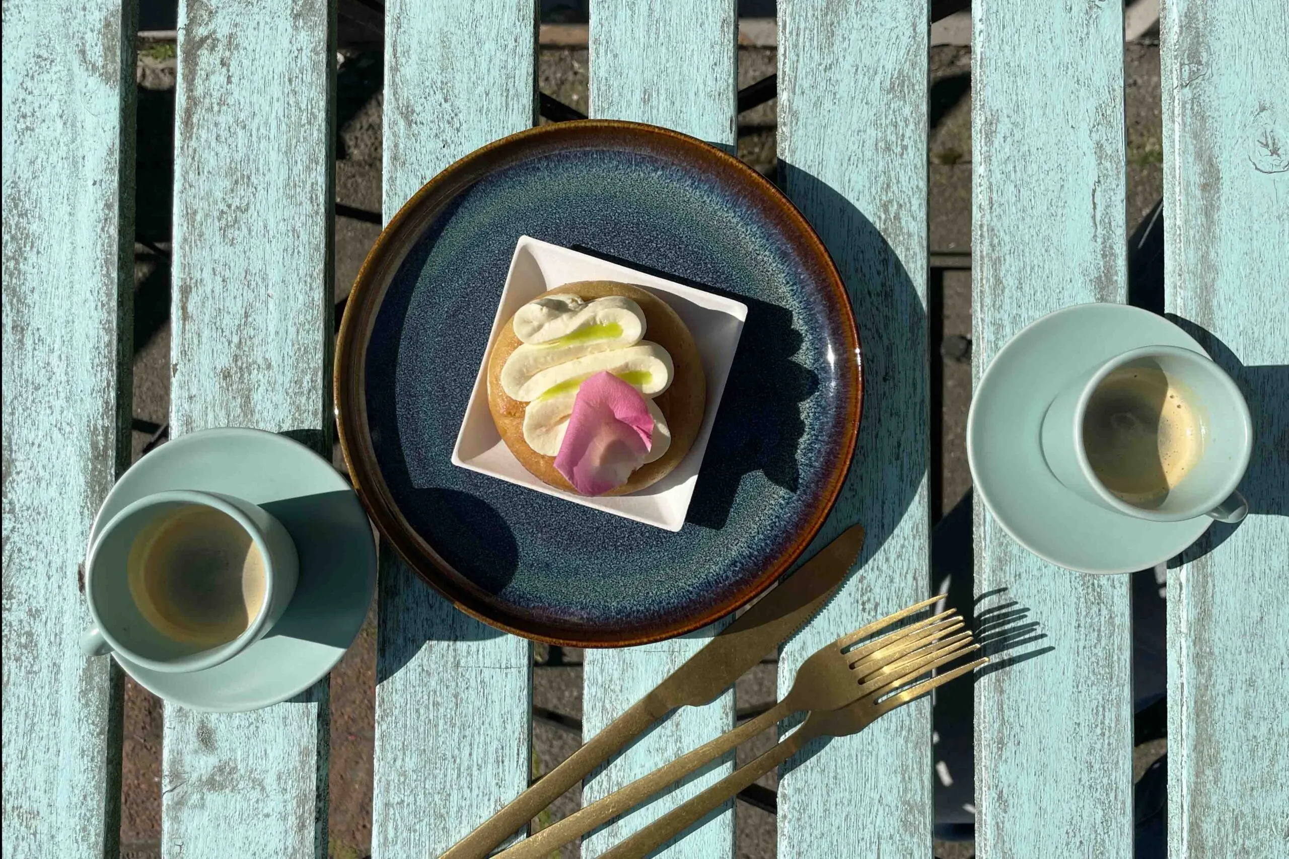 French pastry with cream and rose petal served with espresso at Sweet Aurora Reykjavik.