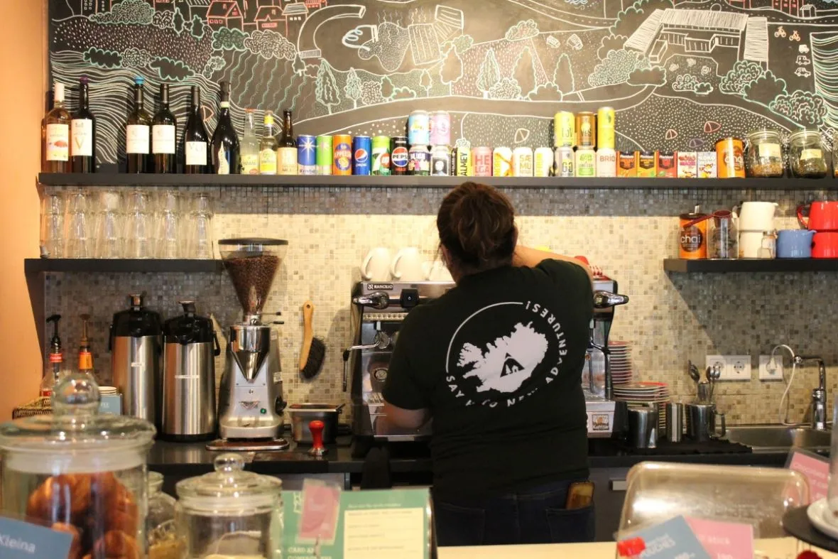 Barista preparing coffee at Dalur Cafe counter in Reykjavik.