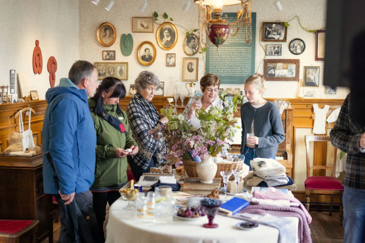 Visitors browsing local crafts and vintage decor inside the cozy Flóra menningarhús museum room.