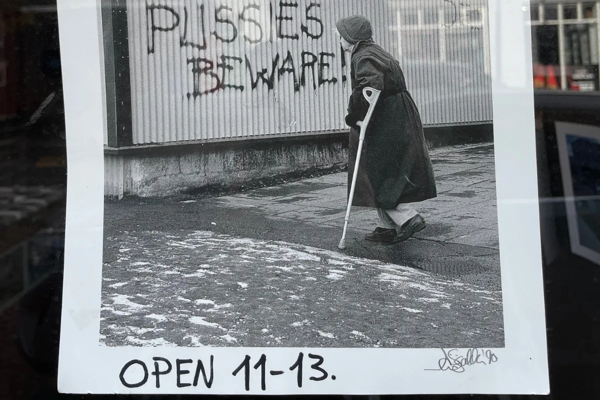 Photography print of an elderly person walking past graffiti at Fótógrafí