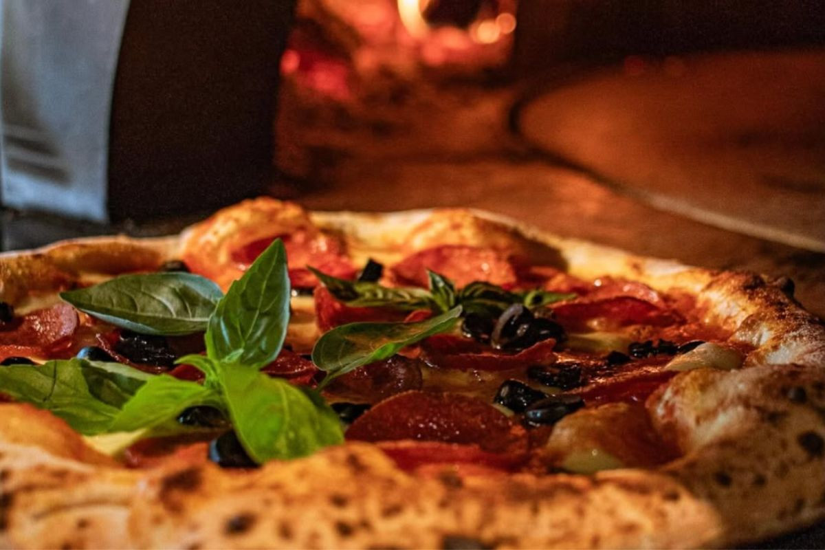 Pepperoni and olive pizza topped with fresh basil at Gott Restaurant, Vestmannaeyjar.