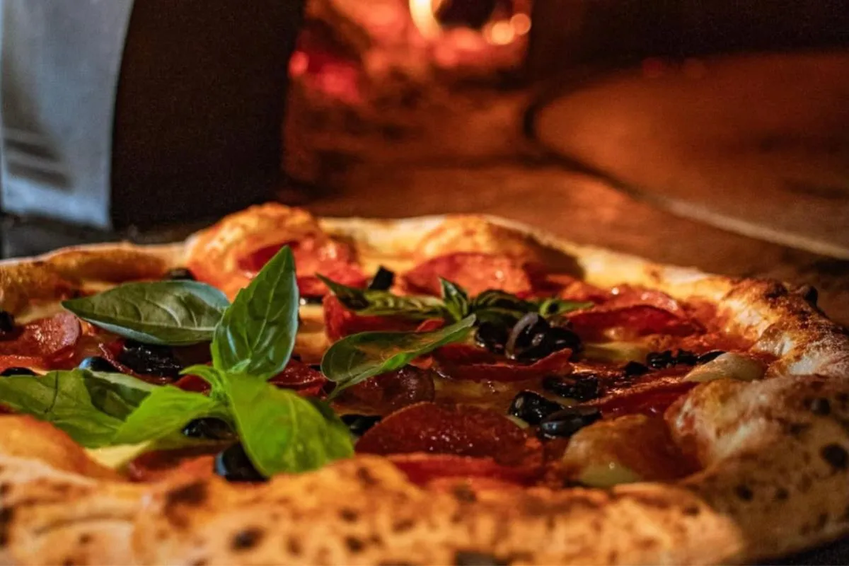 Pepperoni and olive pizza topped with fresh basil at Gott Restaurant, Vestmannaeyjar.