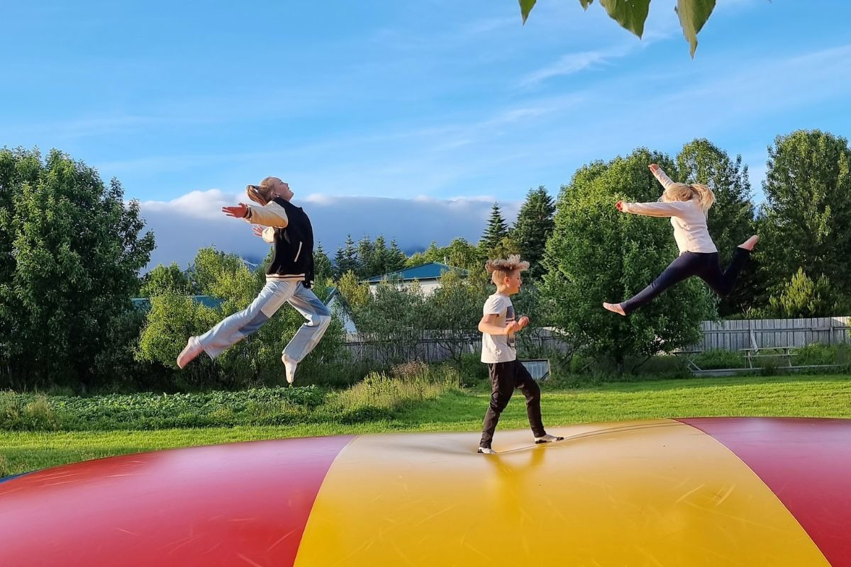 Children jumping on an outdoor air trampoline at Miðhraun Lava Resort.