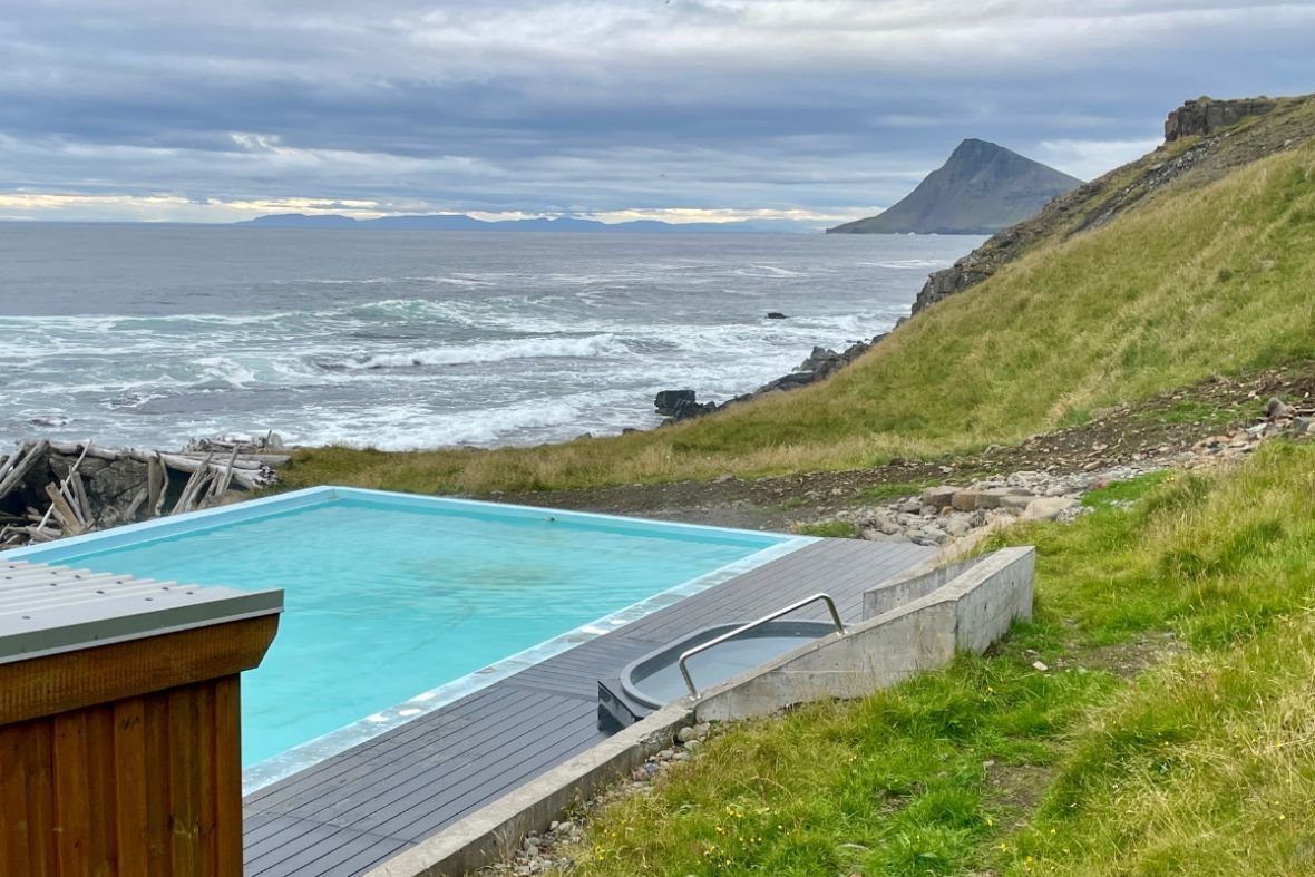 Krossneslaug pool overlooking the ocean and coastal mountains in the Westfjords.
