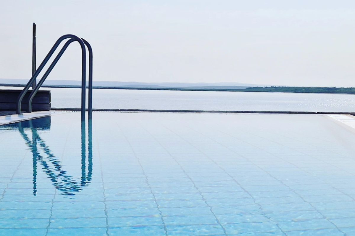 Clear infinity pool with handrails looking out over the lake at Laugarvatn Fontana.
