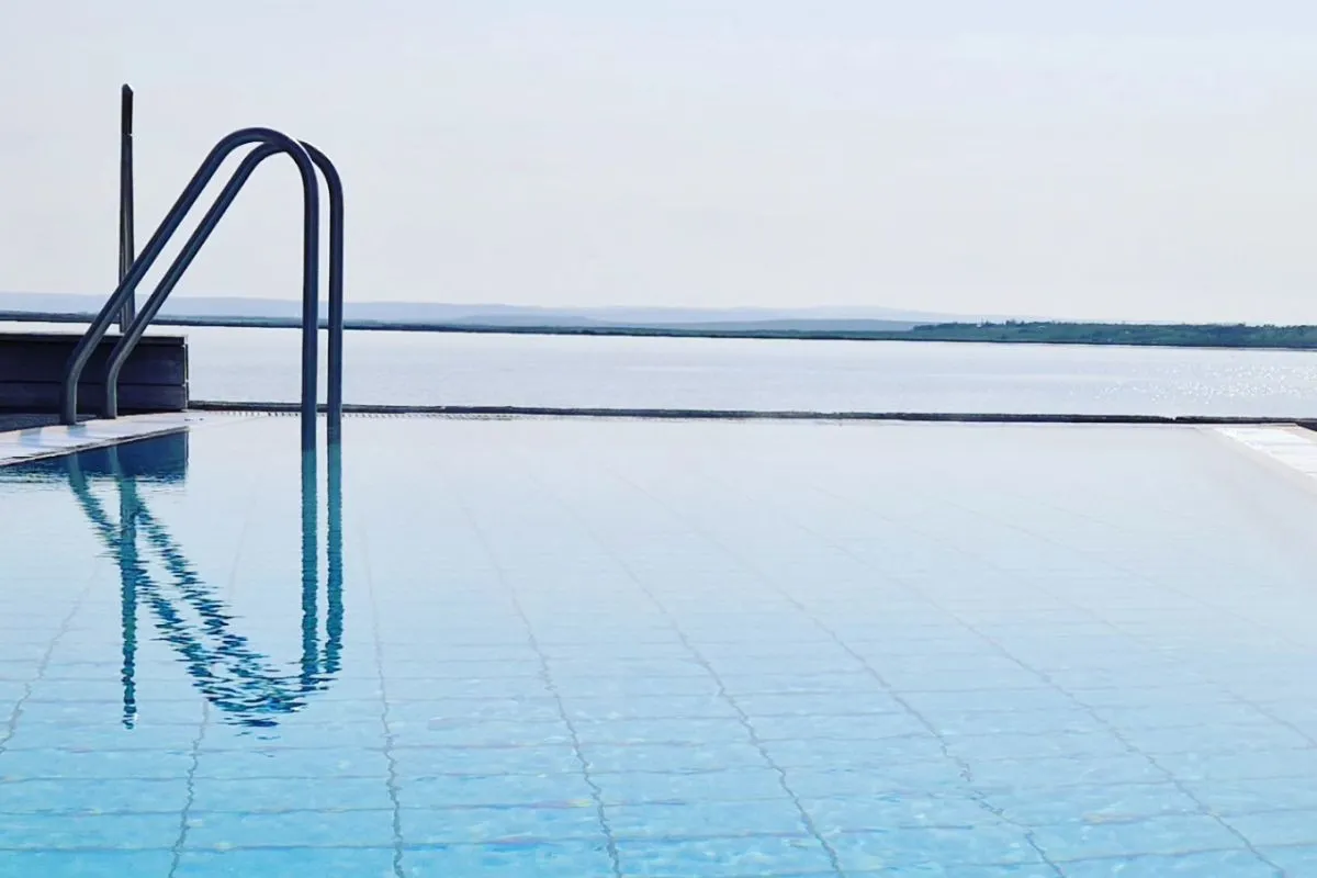 Clear infinity pool with handrails looking out over the lake at Laugarvatn Fontana.