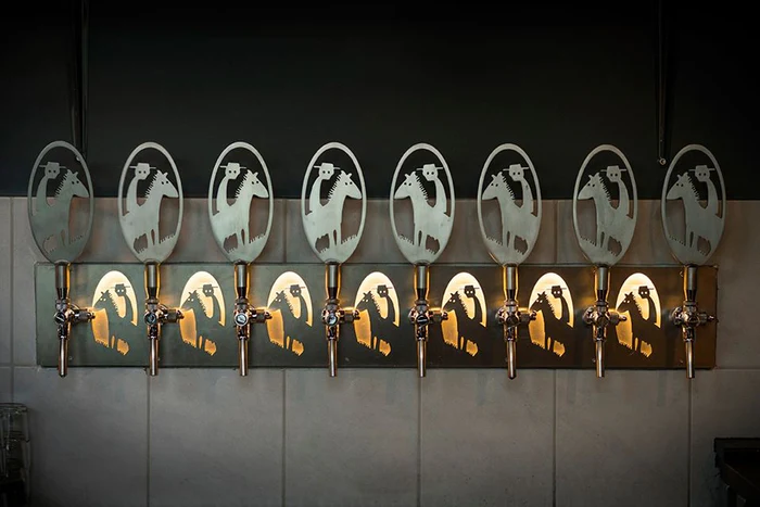 A craft beer tasting flight on a wooden bar at Microbar & Brugg in Kópavogur.