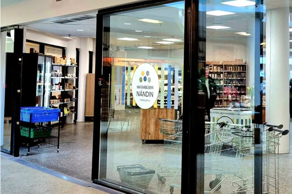 The glass storefront and entrance of Matarbúðin Nándin grocery store in Reykjavik, recommended by Handpicked Iceland.
