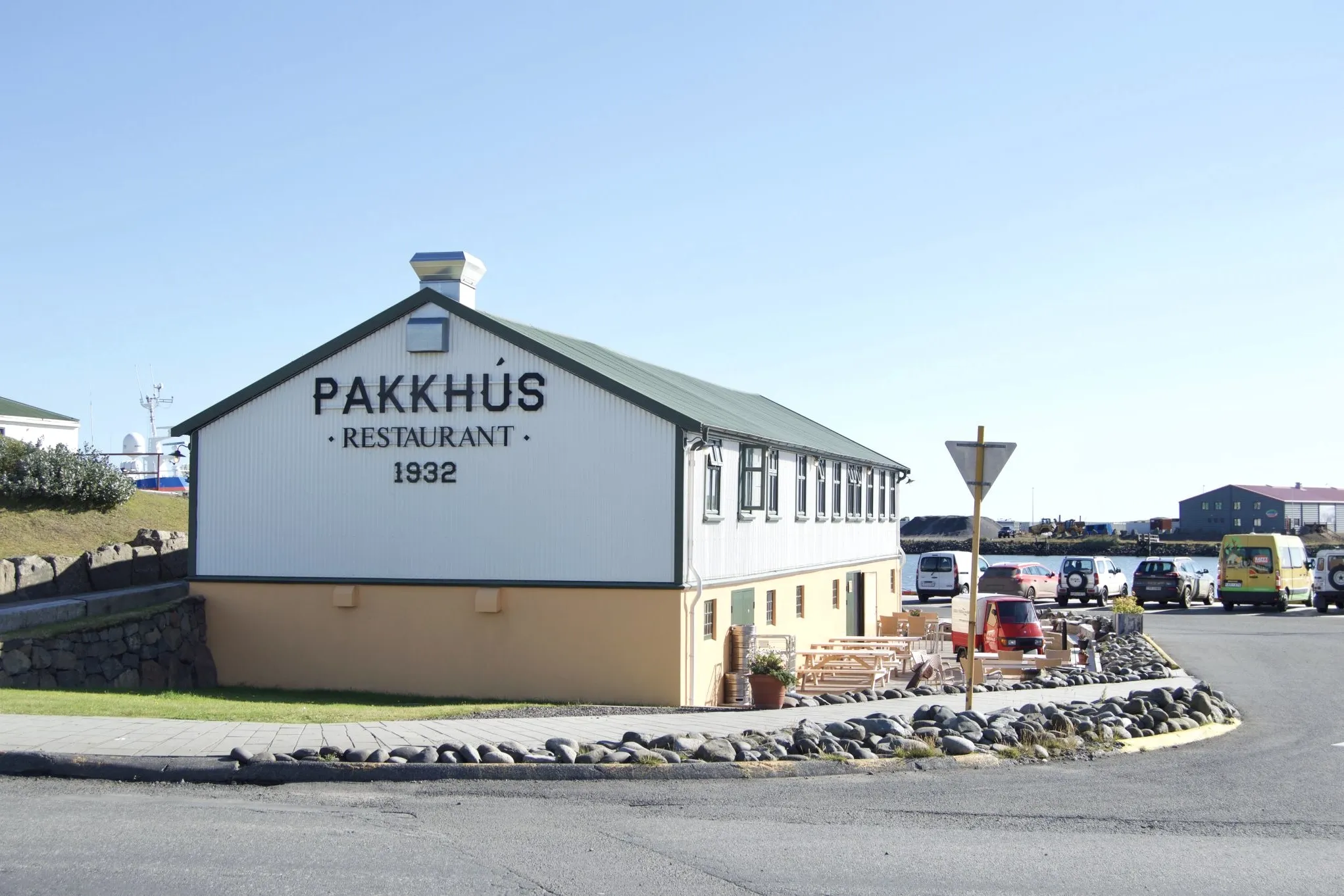 Pakkhúsið Restaurant exterior, historic 1932 warehouse with outdoor seating at Höfn harbor.