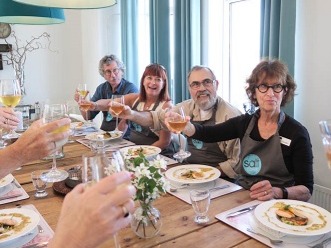 Travelers enjoying a wine toast and Icelandic meal at Salt Eldhús Cook & Dine in Reykjavik.