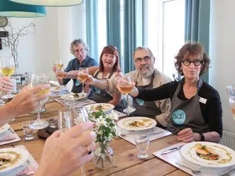 Travelers enjoying a wine toast and Icelandic meal at Salt Eldhús Cook & Dine in Reykjavik.