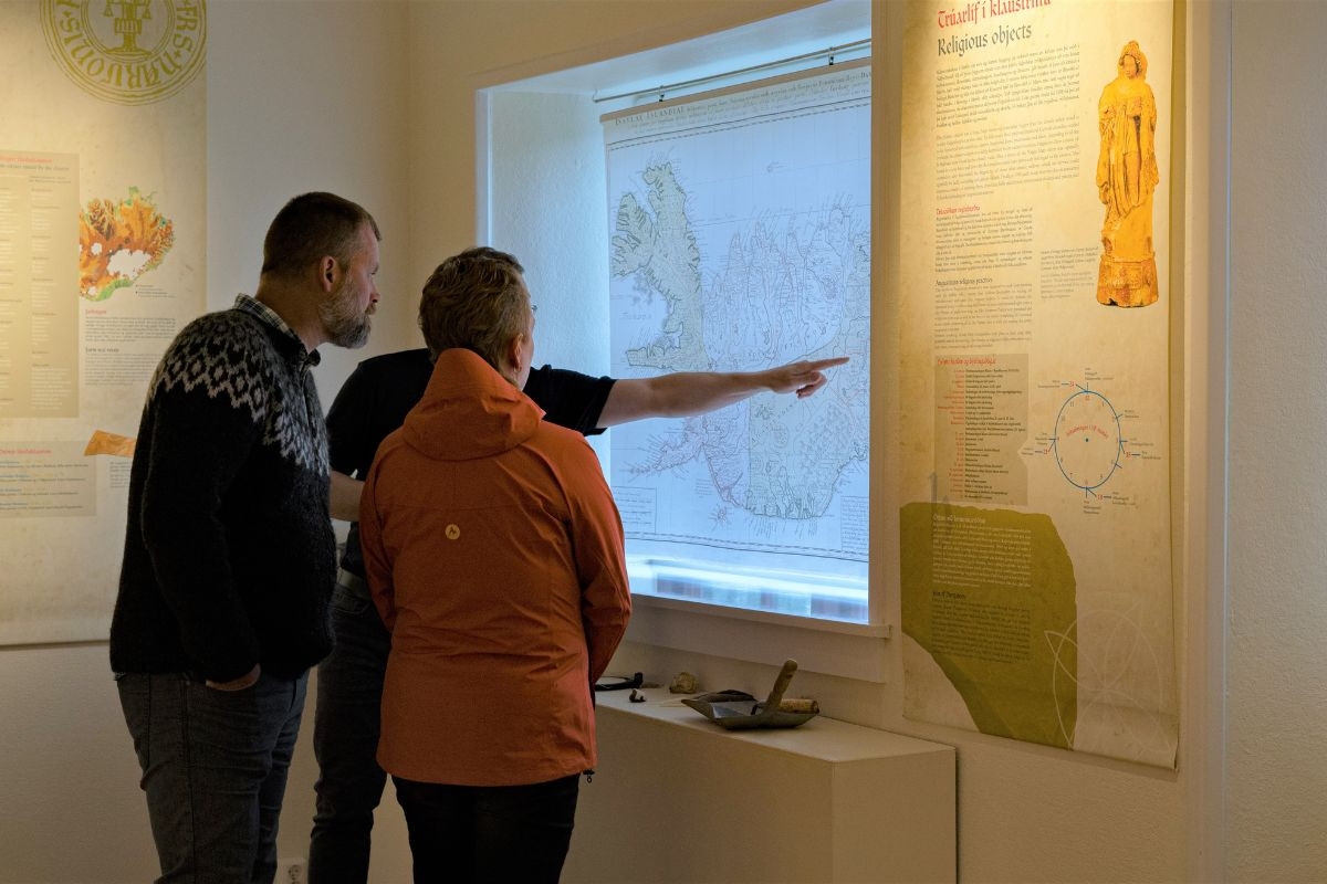 Visitors viewing maps and displays at Skriðuklaustur Culture Center.