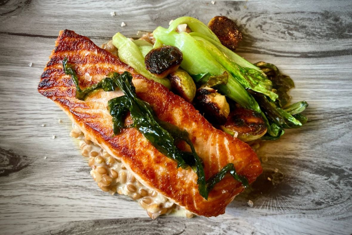 Pan-seared salmon with roasted vegetables and risotto at Tryggvaskáli Restaurant, Selfoss, recommended by Handpicked Iceland.