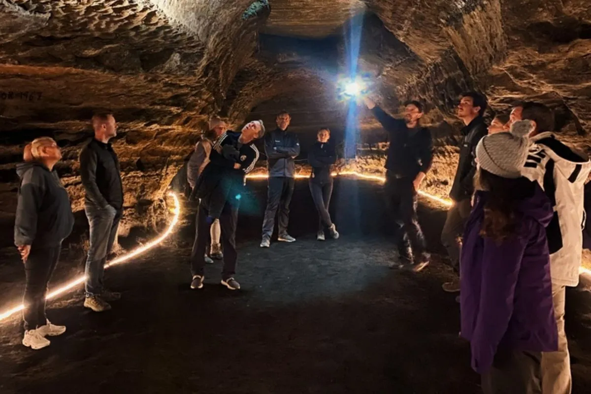 Interior tour experience at the Caves of Hella featuring illuminated floor paths and textured walls.