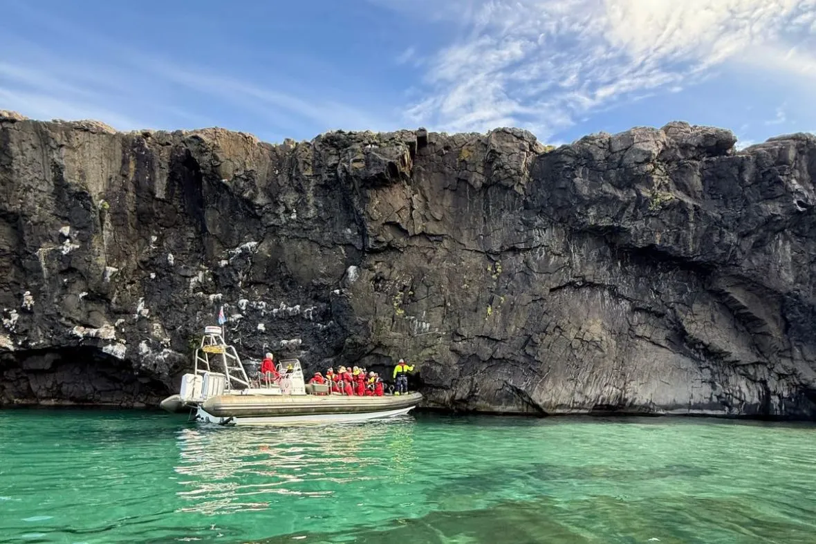 Fjarðaferðir RIB boat tour exploring coastal caves and cliffs near Neskaupstaður.