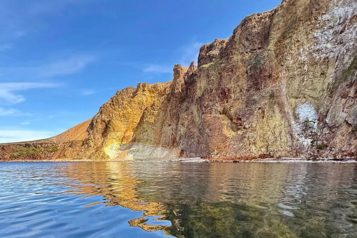 Coastal rock formations and mountain scenery in Neskaupstaður, East Iceland, accessible via Fjarðaferðir tours.