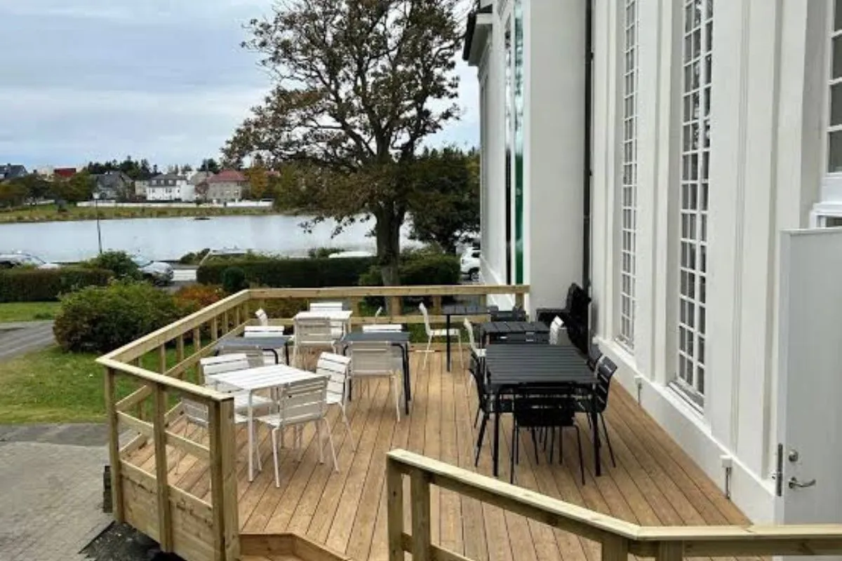 Outdoor wooden terrace at Kaktus Espressobar overlooking Lake Tjörnin in Reykjavik.