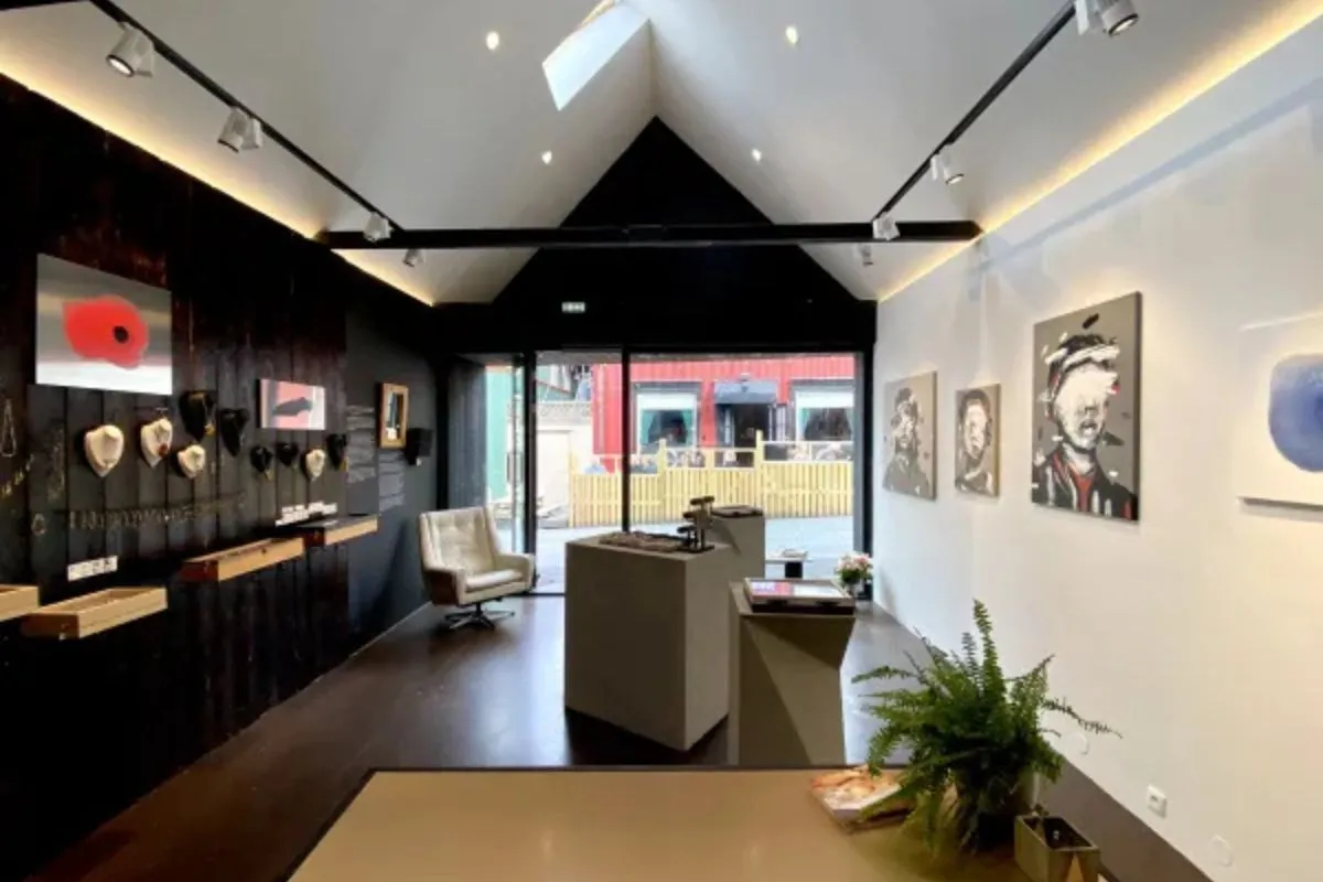 Interior view of RAF Gallery in Reykjavik featuring modern art portraits and jewelry displays.