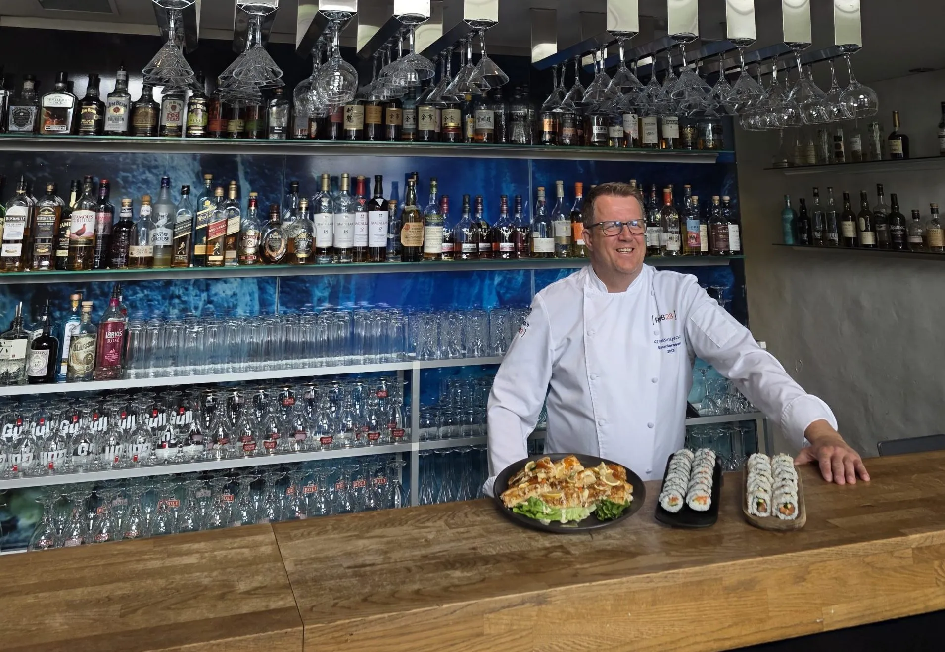 Einar Geirsson standing behind the bar at Rub23 with sushi dishes