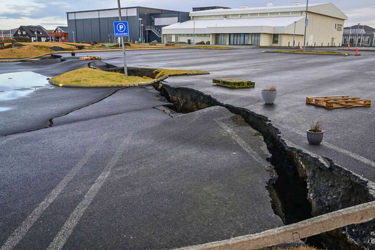 A deep earthquake fissure ripping through an asphalt parking lot in the town of Grindavík.
