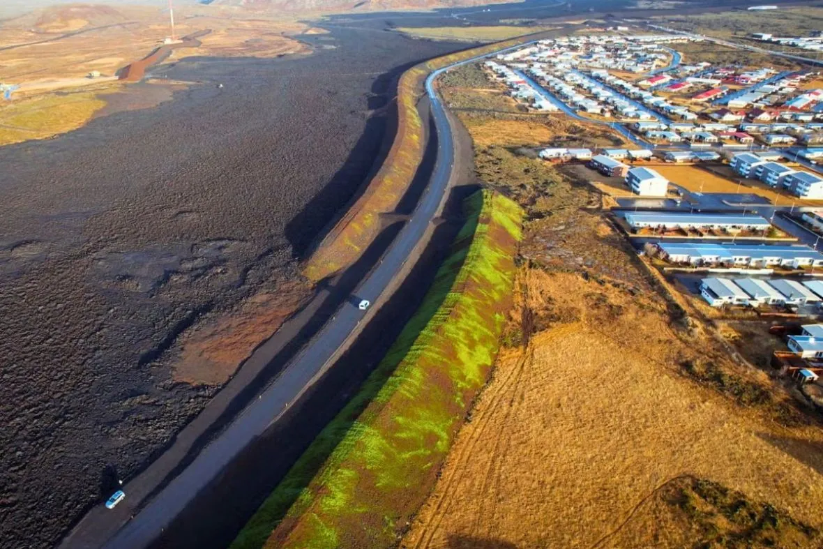 A large earthen volcanic defense wall built alongside a main road to protect the town with with Discover Grindavík.