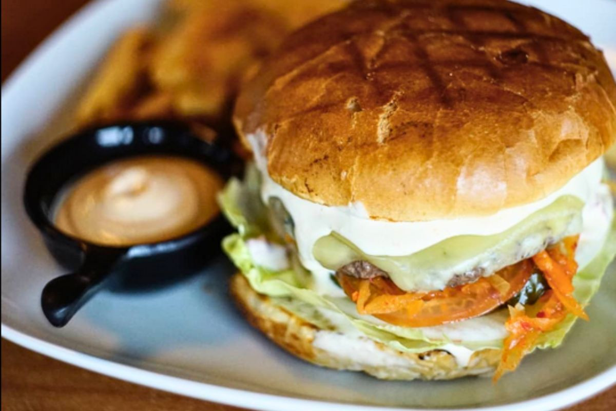 Gourmet beef burger with melted cheese and dipping sauce at Bragðavellir Cottages & Restaurant, East Iceland, recommended by Handpicked Iceland.