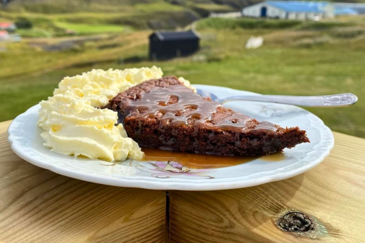 A slice of chocolate cake with caramel sauce and whipped cream served outdoors at HAK bistro & café in Egilsstaðir.