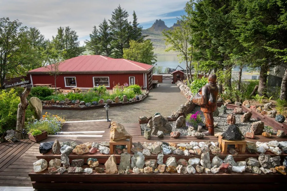An outdoor display of colourful geological specimens and stones at Petra's Stone Collection in Stöðvarfjörður East Iceland, recommended by Handpicked Iceland.