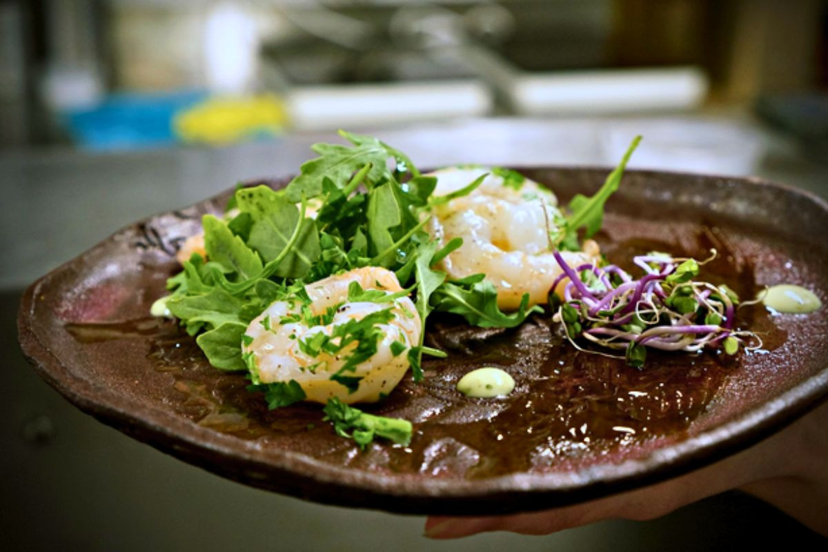 Gourmet shrimp appetizer with fresh greens served at Hraunsnef Steakhouse.