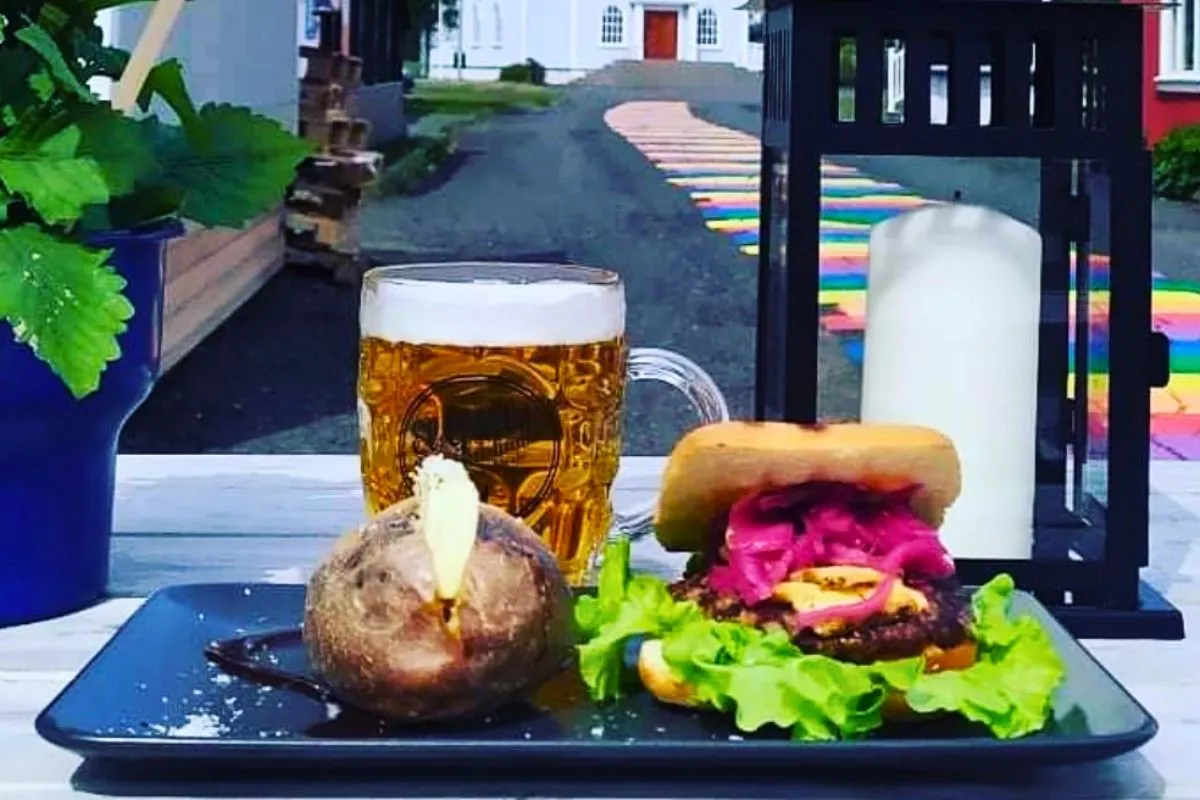 A burger, baked potato, and a pint of beer at Kaffi Lára El Grillo Bar along the rainbow road.